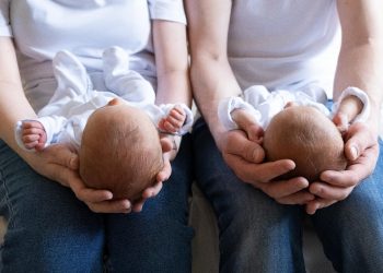 Jumeaux dans les mains des parents.